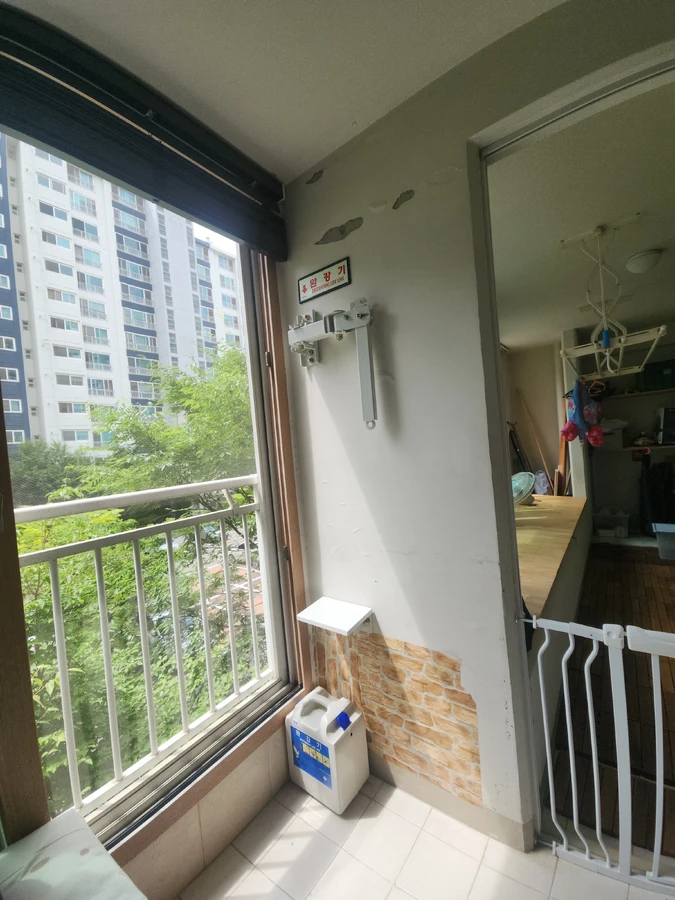 블라인드가 달린 베란다 창가에 설치된 완강기 표지판과 함